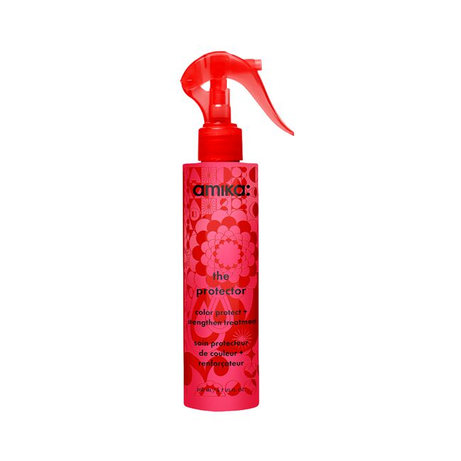 Amika The Protector Color Protect Hair Enhancing Treatment in a red spray bottle with a red trigger sprayer, set against a plain white background.