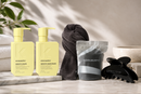 Kevin Murphy hair care products including bottles, a towel, and a bag on a marble surface - Hair Care Canada
