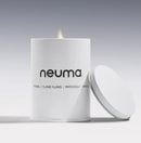 Neuma candle with lid on a gray background - Hair Care Canada