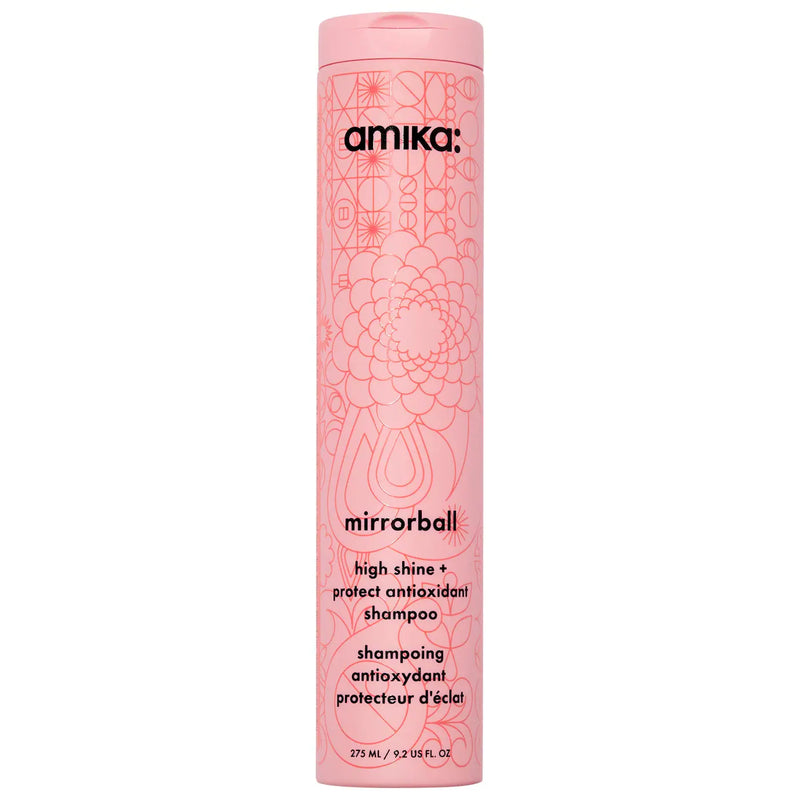 A tall, cylindrical pink bottle of amika mirrorball high shine protectant antioxidant shampoo, featuring a pink cap and a floral line-art pattern on a white background Hair Care Canada