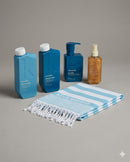 Set of skincare products including bottles and a towel on a gray background - Hair Care Canada